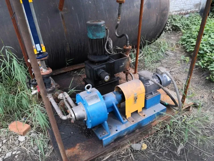 Blue EHIK pump with a yellow coupling guard beside a storage tank at the Shanxi Sanqiang ammonium nitrate wastewater site.