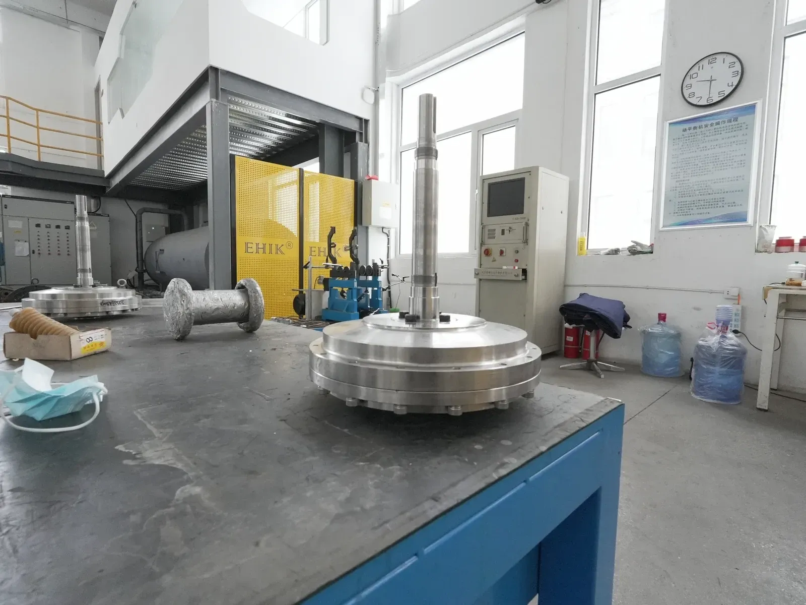 An EHIK rotor assembly with its shaft and circular rotor body in the workshop.