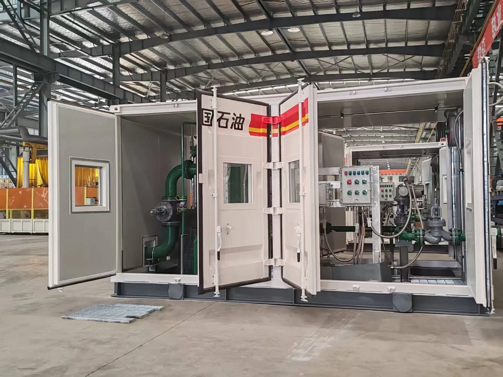 Open enclosure of the Xinjiang project equipment showing internal pipework, valves, instruments and control panels.