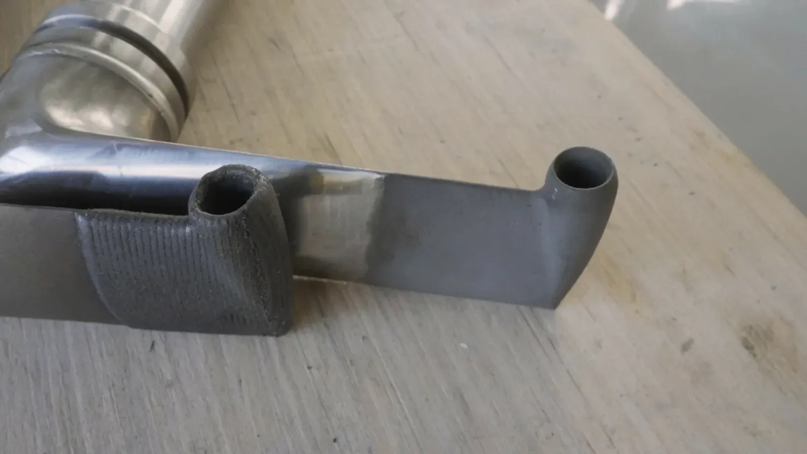 Two pickup-tube inlet details, one with a dark textured surface treatment and one with a smooth metal surface.