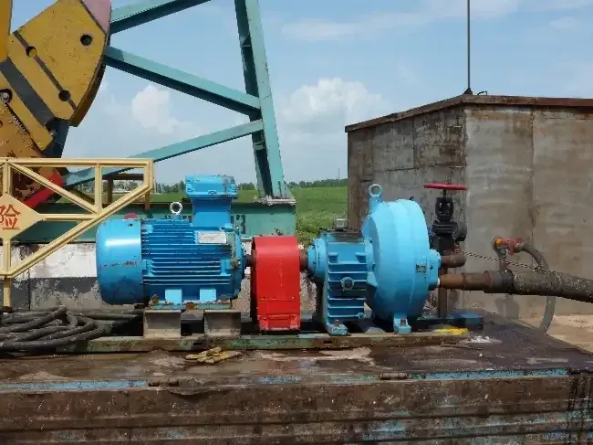 EHIK blue pump and motor installed near oilfield equipment for hot-water well cleaning in 2010.