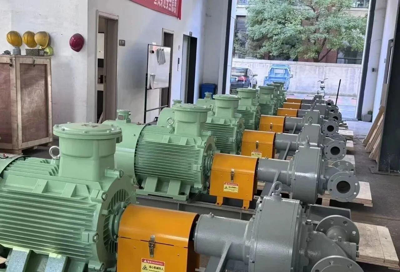 A row of EHIK pump sets with pale-green explosion-proof motors and orange coupling guards in the workshop.
