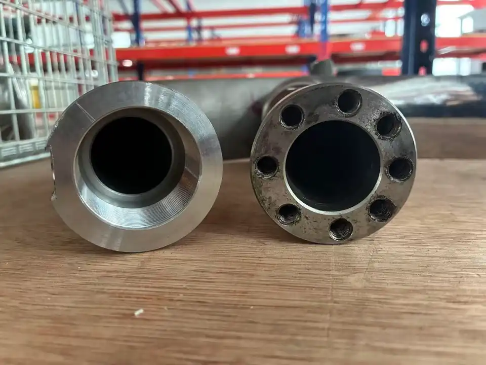 EHIK threaded pickup tube connection at left beside a multi-bolt connection at right.